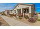 Modern stucco home with a covered porch and drought-tolerant landscaping at 14104 W Bronco Trl, Surprise, AZ 85387