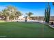 Large backyard with putting green, pool, and desert landscaping at 16118 W Gibson Ln, Goodyear, AZ 85338