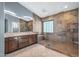 Spa-like bathroom with double vanity, large shower, and stone tile at 16118 W Gibson Ln, Goodyear, AZ 85338