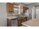 Kitchen features a farmhouse sink, stainless steel dishwasher, and wood cabinets at 16118 W Gibson Ln, Goodyear, AZ 85338