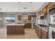 Spacious kitchen with island, stainless steel appliances, and dark wood cabinets at 16118 W Gibson Ln, Goodyear, AZ 85338