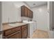 Laundry room with washer, dryer, cabinets, and a utility sink at 16118 W Gibson Ln, Goodyear, AZ 85338