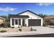 Single-story home with white and dark gray exterior, landscaping, and a two-car garage at 16530 N Dante Way, Maricopa, AZ 85138