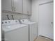 Bright laundry room, featuring washer, dryer, and storage cabinets at 1703 E Laguna Dr, Tempe, AZ 85282