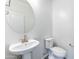 Modern half bathroom with white pedestal sink and elongated toilet at 17469 N 66Th Ave, Glendale, AZ 85308