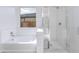 Close up on bathroom with a tub, white subway tile, and a glass shower enclosure at 17469 N 66Th Ave, Glendale, AZ 85308