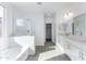 Bright bathroom with white subway tile, glass shower, soaking tub, and double vanity sinks at 17469 N 66Th Ave, Glendale, AZ 85308