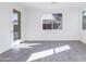 Bright bedroom featuring hard floors, white walls, a glass door to the patio, and a window at 17469 N 66Th Ave, Glendale, AZ 85308