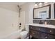 Clean bathroom, featuring dark vanity, tile backsplash, and a tub at 18487 N 111Th Dr, Surprise, AZ 85378