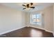 Spacious bedroom featuring wood floors, a ceiling fan, and a large window at 18487 N 111Th Dr, Surprise, AZ 85378