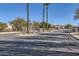 Gated community entrance with palm trees and paved road at 18487 N 111Th Dr, Surprise, AZ 85378