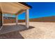 View of the backyard, with a covered patio, columns, and a block wall surrounding the property at 18556 E Dario Rd, Gold Canyon, AZ 85118