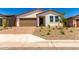 Charming single-story home with a desert landscape and a brown two car garage at 18556 E Dario Rd, Gold Canyon, AZ 85118