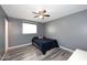 Bedroom with ceiling fan, wood-look floors, and window letting in plenty of natural light at 1905 W 2Nd St, Mesa, AZ 85201