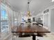 Large wooden dining table surrounded by white chairs with a view into the modern kitchen at 19531 N 69Th Ave, Glendale, AZ 85308