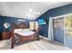 Large bedroom with ceiling fan, dark blue walls, wood frame bed, and sliding glass doors at 19531 N 69Th Ave, Glendale, AZ 85308