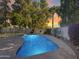 Beautiful backyard pool with cool blue water, surrounded by lush landscaping and a concrete patio at 19531 N 69Th Ave, Glendale, AZ 85308