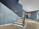 Modern staircase with blue walls and wood accents, leading to the upper level at 19531 N 69Th Ave, Glendale, AZ 85308