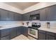 Kitchen with dark gray cabinets, quartz countertops, and stainless steel appliances at 2217 E Devon Ct, Gilbert, AZ 85296