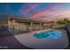 Backyard features a refreshing pool with safety fence under a colorful sunset sky at 2217 E Devon Ct, Gilbert, AZ 85296