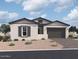 Single-story home with gray and white exterior, two-car garage, and landscaping at 22717 E Saddle Way, Queen Creek, AZ 85142