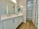 Bathroom featuring wood-look floors, double sinks and vanity, white cabinets, and a shower-tub combo at 22740 E Lords Way, Queen Creek, AZ 85142