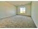 Neutral bedroom offers plush carpeting and a sunny window at 22740 E Lords Way, Queen Creek, AZ 85142