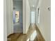 Hallway showcasing the wood-look floors, white walls, and doorways to the bathroom and bedroom at 22740 E Lords Way, Queen Creek, AZ 85142