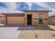 Charming single-story home featuring a two-car garage and a stone-accented facade with a well-maintained front yard at 24153 W Hilton Ave, Buckeye, AZ 85326