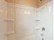 Clean white shower and bath combination with built-in shelves and chrome fixtures at 24153 W Hilton Ave, Buckeye, AZ 85326