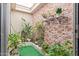 Peaceful courtyard garden with brick wall and skylight at 25227 S Mohawk Dr, Sun Lakes, AZ 85248