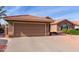 Tan house with tile roof, garage, and landscaped yard at 25432 S Queen Palm Dr, Sun Lakes, AZ 85248