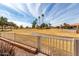 View of a lush green golf course from behind a white fence at 25432 S Queen Palm Dr, Sun Lakes, AZ 85248