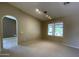 Open living room with neutral carpet and archway leading to another room at 25432 S Queen Palm Dr, Sun Lakes, AZ 85248