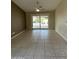 Open living room with tiled floor and sliding glass door to patio at 25432 S Queen Palm Dr, Sun Lakes, AZ 85248