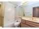 Bright bathroom featuring a bathtub with gold fixtures, a large mirror, and neutral tile at 25440 S Flame Tree Dr, Sun Lakes, AZ 85248