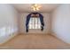 Bright bedroom with neutral carpet, a ceiling fan, and a window with a colorful decorative valance at 25440 S Flame Tree Dr, Sun Lakes, AZ 85248