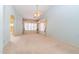 Spacious bedroom featuring neutral carpet, a ceiling fan, and a window with colorful custom draperies at 25440 S Flame Tree Dr, Sun Lakes, AZ 85248