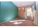 Dining room with an ornate chandelier, large window with curtains, and a neutral colored wall with turquoise accent wall at 25440 S Flame Tree Dr, Sun Lakes, AZ 85248