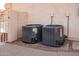 Two air conditioning condensers outside a beige building surrounded by gravel and a sidewalk at 25440 S Flame Tree Dr, Sun Lakes, AZ 85248