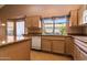 Bright kitchen featuring natural wood cabinetry, granite countertops, and a window overlooking the backyard at 25440 S Flame Tree Dr, Sun Lakes, AZ 85248