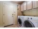 Functional laundry room with washer, dryer, and cabinetry for organized storage at 25440 S Flame Tree Dr, Sun Lakes, AZ 85248