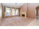 Spacious living room featuring a fireplace, large windows with decorative curtains, and neutral carpeting at 25440 S Flame Tree Dr, Sun Lakes, AZ 85248