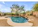 Charming kidney-shaped pool with waterfall feature, surrounded by rocks at 25802 N Hackberry Dr, Phoenix, AZ 85083