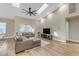 Spacious living room featuring a light brown sectional sofa and light wood flooring at 25802 N Hackberry Dr, Phoenix, AZ 85083