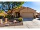 Tan house with a two-car garage and landscaping at 26907 N 51St Dr, Phoenix, AZ 85083