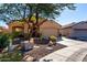 Tan house with a two-car garage and landscaping at 26907 N 51St Dr, Phoenix, AZ 85083