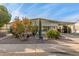 Landscaped yard with mature plants enhances curb appeal of this manufactured home at 2724 N Wright Way, Mesa, AZ 85215