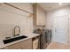 Modern laundry room with a farmhouse sink and ample cabinet space at 3729 E Donald Dr, Phoenix, AZ 85050