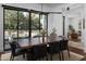 Modern dining room with a large wooden table and black leather chairs, adjacent to the backyard at 3837 E Heatherbrae Dr, Phoenix, AZ 85018